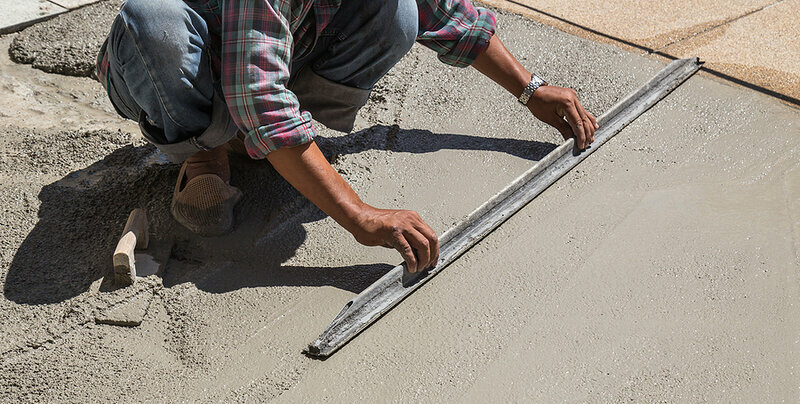 Construction Worker Spreading Wet Concrete