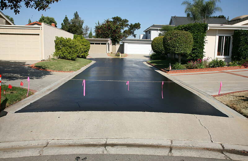 fresh hot tar aka black top on an ashphalt driveway in a neighbo